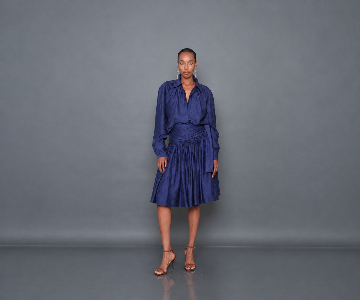Undra Celeste New York Jane Poet Blouse in Navy, crafted from 100% Tencel with a textured finish, gathered neckline, button-front closure, voluminous dolman sleeves, and a relaxed oversized silhouette. Elegant contemporary women's workwear.