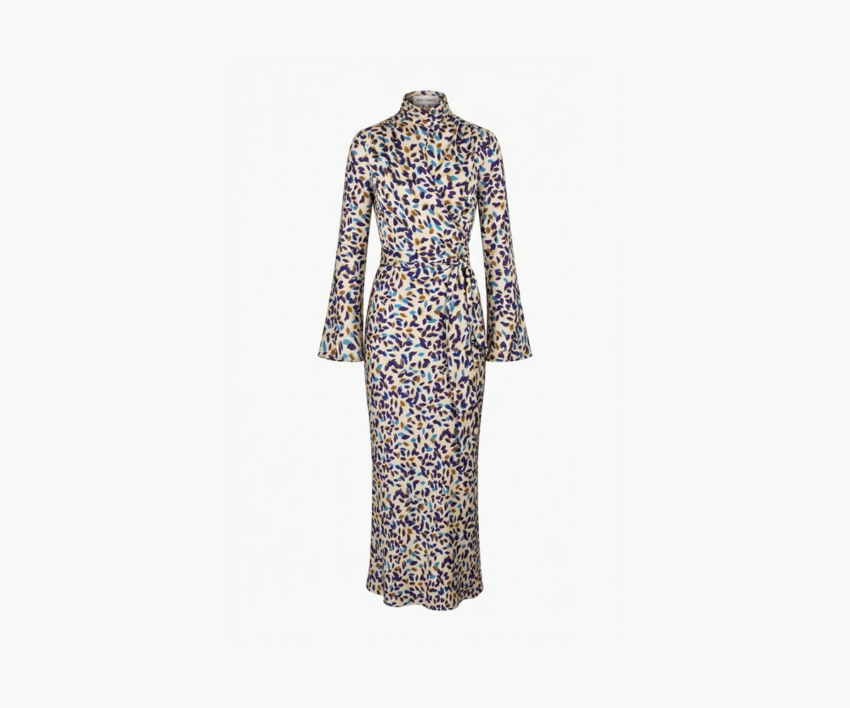 Undra Celeste New York Long Sleeve Mock Neck Joi Dress in Cream Falling Leaves print, crafted from luxurious hammered satin with a soft textured sheen, featuring a mock neckline, long flared sleeves, draped wrap-style bodice, defined waist, and flowing bias-cut maxi skirt. Sophisticated contemporary women's workwear.