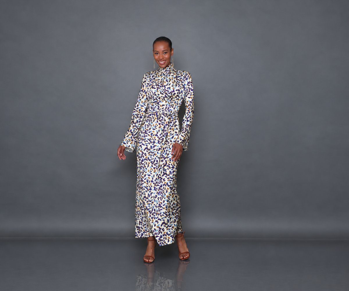 Undra Celeste New York Long Sleeve Mock Neck Joi Dress in Cream Falling Leaves print, crafted from luxurious hammered satin with a soft textured sheen, featuring a mock neckline, long flared sleeves, draped wrap-style bodice, defined waist, and flowing bias-cut maxi skirt. Sophisticated contemporary women's workwear.