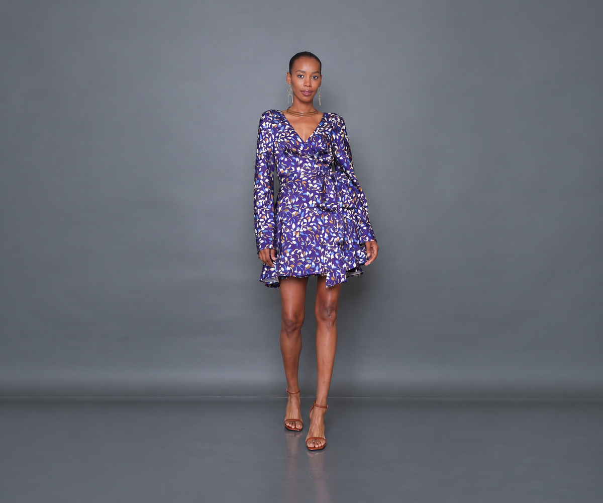 Undra Celeste New York Shonda Mini Wrap Dress in Purple Falling Leaves print, crafted from luxurious hammered satin with a deep V-neckline, long flared sleeves, adjustable wrap waist, oversized self-tie sash, and flowing mini-length skirt. Elevated contemporary women's workwear.