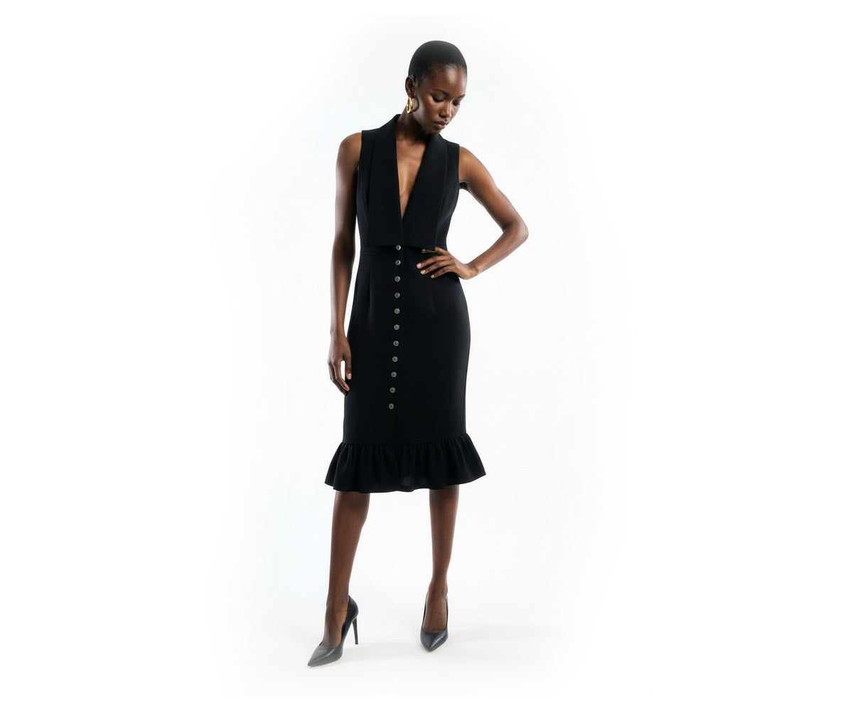Undra Celeste New York Vivi Vest Dress in Black, featuring a deep V-neckline with tailored vest-style lapels, sleeveless silhouette, fitted waist, elegant button-front closure, and a sculpted midi-length skirt with a feminine ruffled hem. A sophisticated statement dress for elevated contemporary women's workwear.